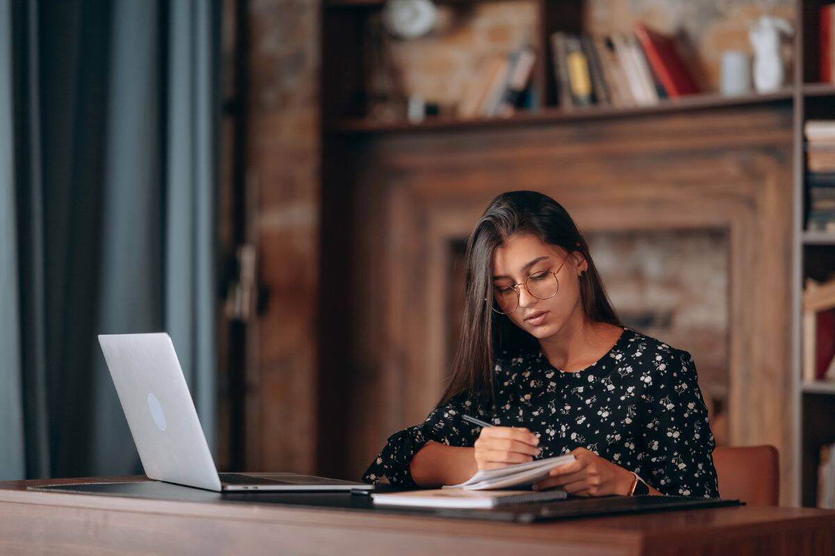 Bela mulher de negócios escrevendo algo em um caderno