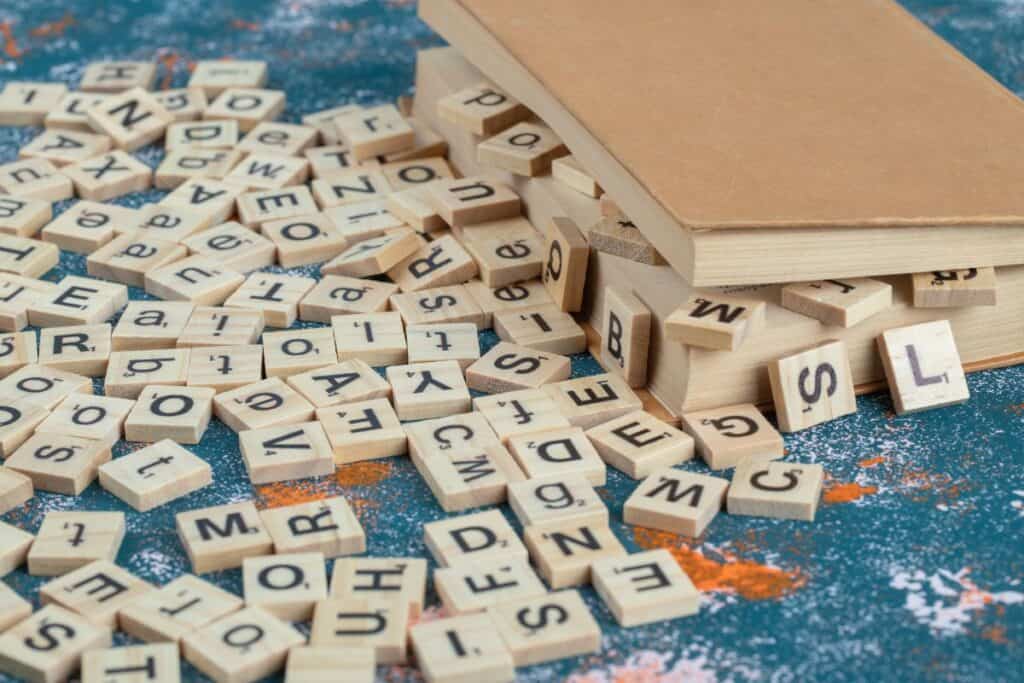 Spiegazione dei palindromi: significato, tipi ed esempi facili 4 Dadi di legno con lettere incise tra le pagine di un libro