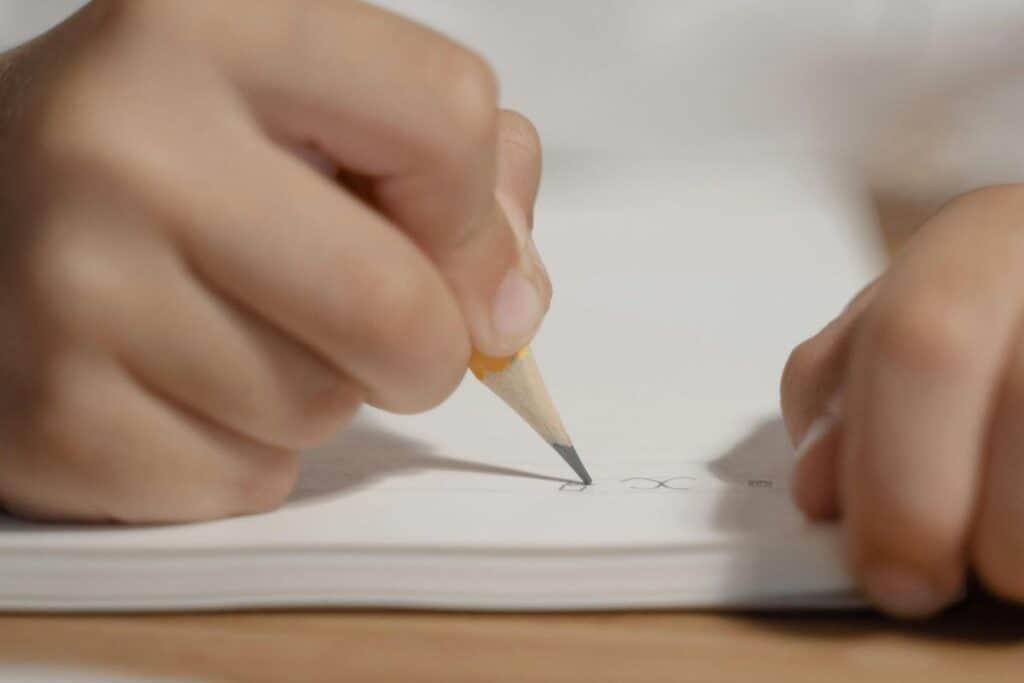 A Person Writing on a Notebook