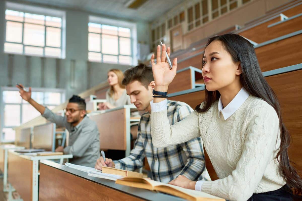 Students raising hands in college