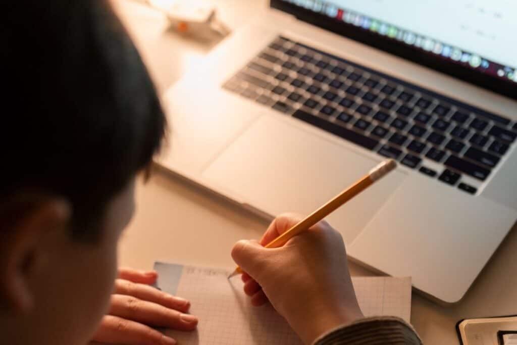 Principais alternativas ao Grammarly para melhorar sua redação 4 Close de criança fazendo lição de casa com laptop