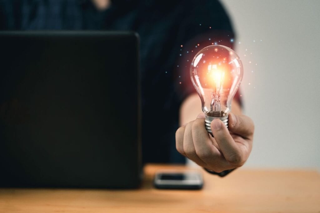 Businessman hand holding lightbulb with glowing light