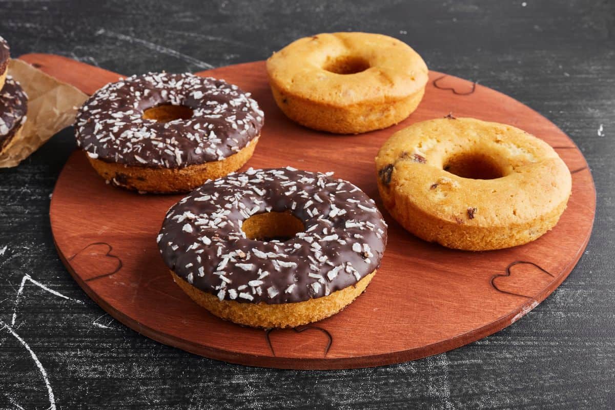 Chocolate doughnuts on a round wooden platter