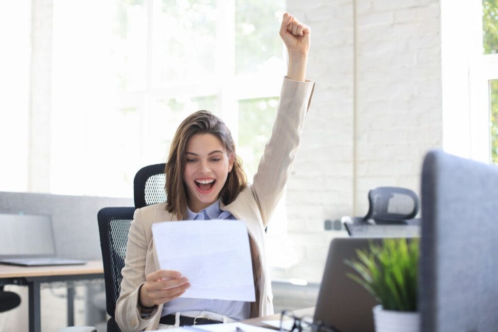Attractive cheerful business woman read goog news from paper documents