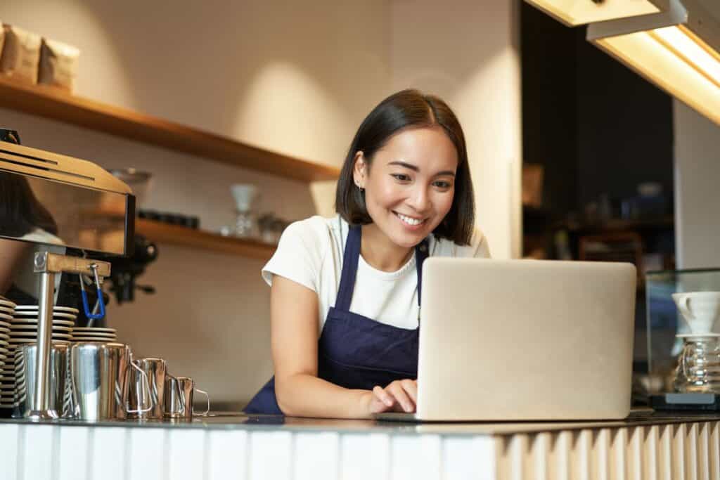 Las 10 mejores estrategias para desarrollar su capacidad empresarial 4 Retrato de barista asiático sonriente propietario de cafetería