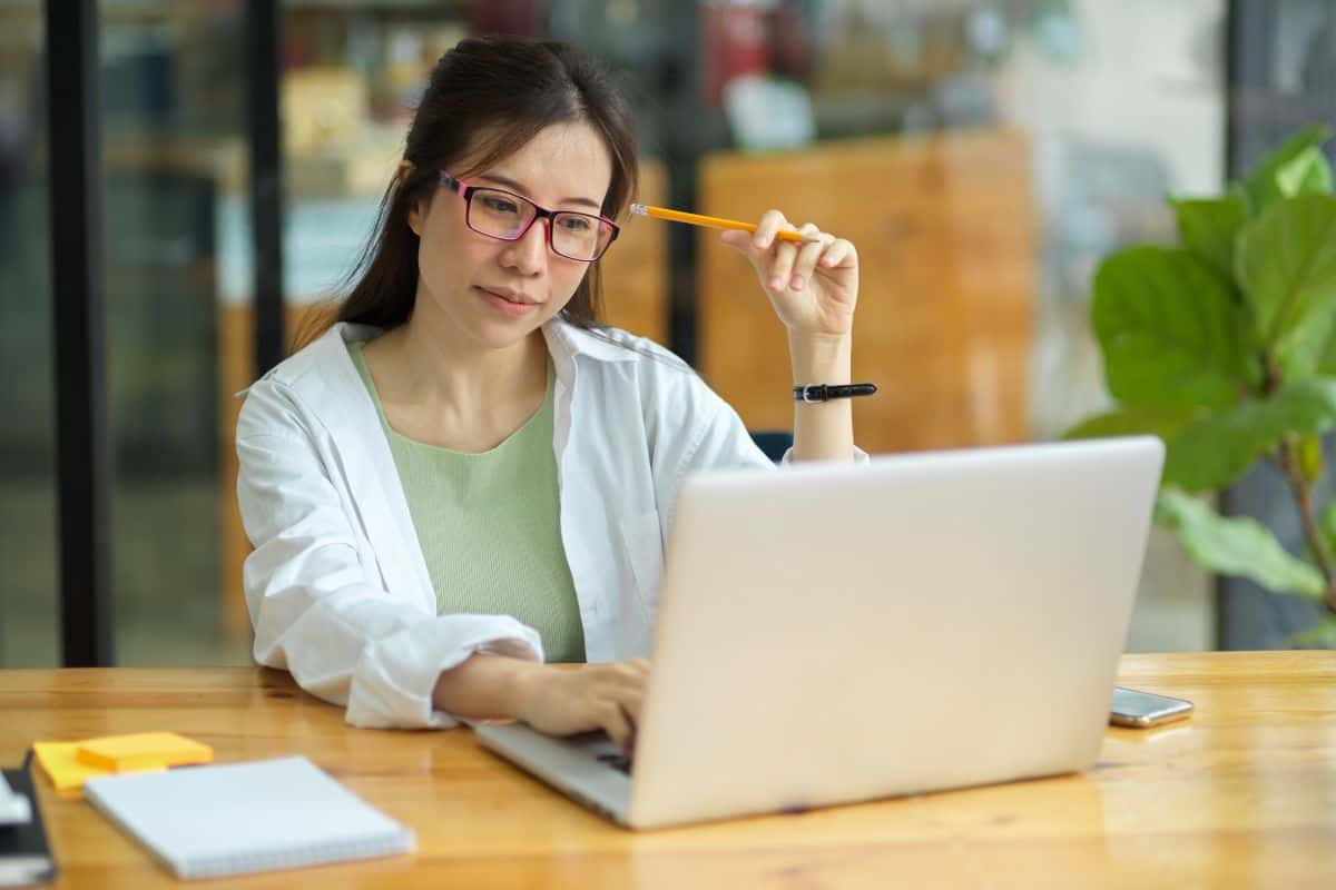 Young woman using mobile phone while sitting on table